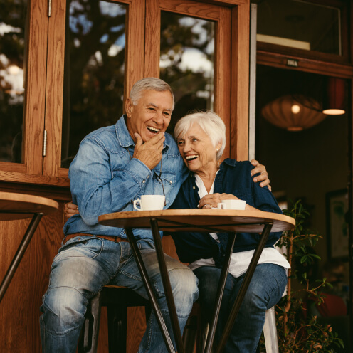 smiling senior couple at cafe table