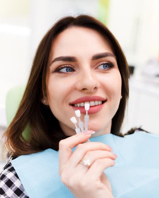 woman getting teeth color-matched in dental chair
