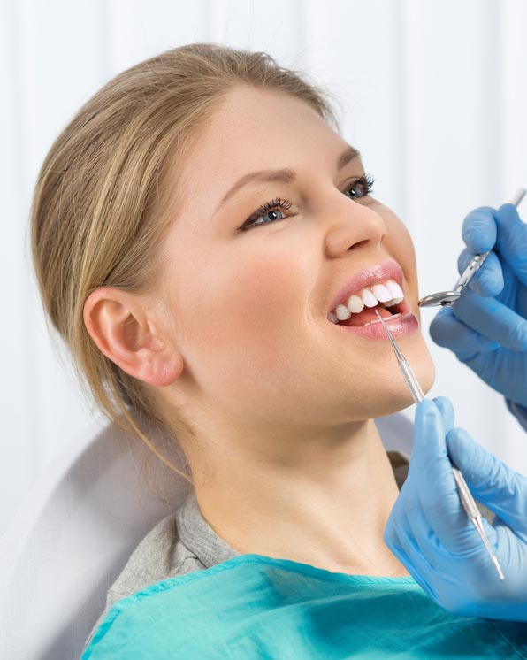 woman in dental chair smiling undergoing dental exam