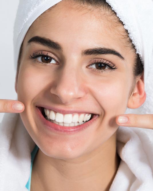 woman pointing at her smile