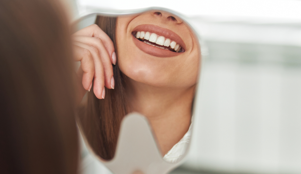 woman looking at smile in a mirror