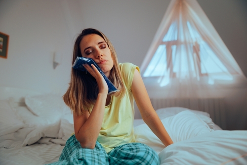 woman holding ice pack to her jaw