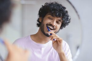 Man,Brushes,His,Teeth,In,Front,Of,A,Mirror