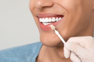 Doctor,Checking,Young,Man's,Teeth,Color,On,Gray,Background,,Closeup.
